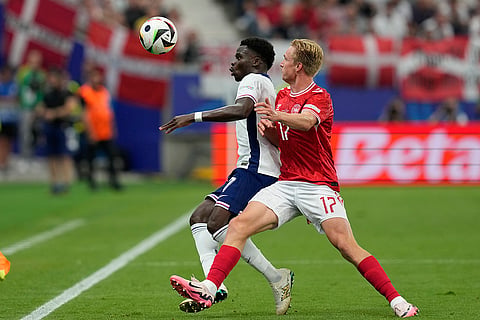 Victor Kristiansen and Bukayo Saka compete for the ball